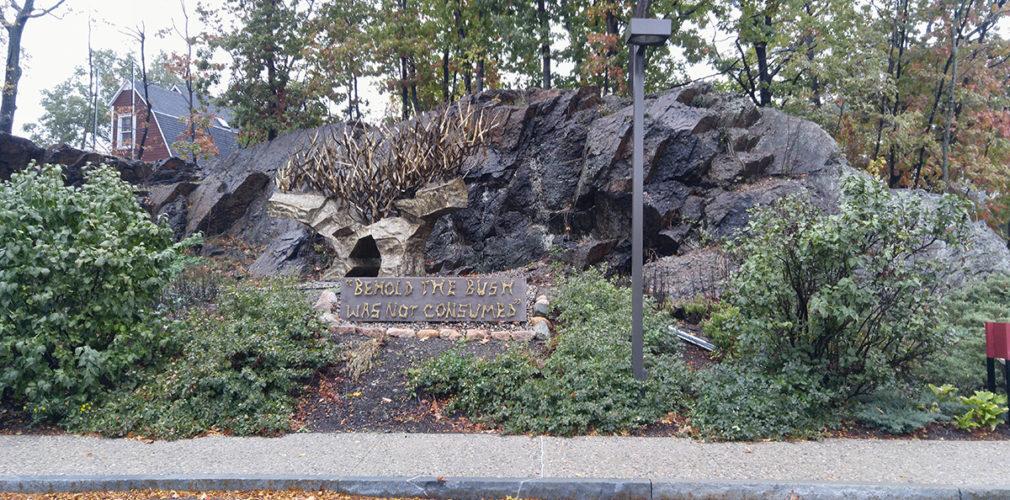 Large Rock Feature And A Sculpture Of The Burning Bush With The Quote "behold The Bush Was Not Consumed"